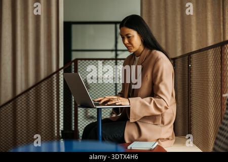 Geschäftsfrau, die im Büro sitzt und arbeitet Stockfoto