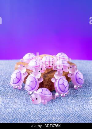 Eine Nahaufnahme einer Reihe violetter, verspielter Schildkröten-Innenfiguren, die auf einer Holzbühne angeordnet sind Stockfoto