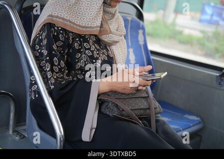 Frau, die ein Smartphone benutzt, während sie auf dem Bussitz sitzt Stockfoto