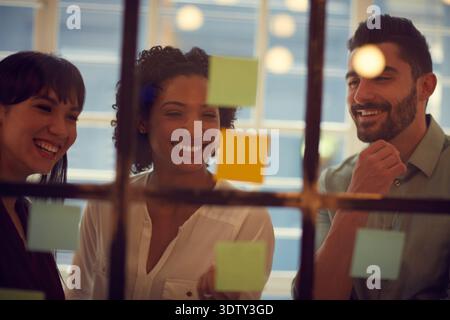 Team, Geschäftsleute und Brainstorming an Glaswänden, Planung und Journalist mit kreativer Agenda. Haftnotiz, Strategie und Denken im Büro Stockfoto