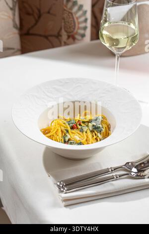 Cremige Spinatnudeln in weißer Schüssel Stockfoto