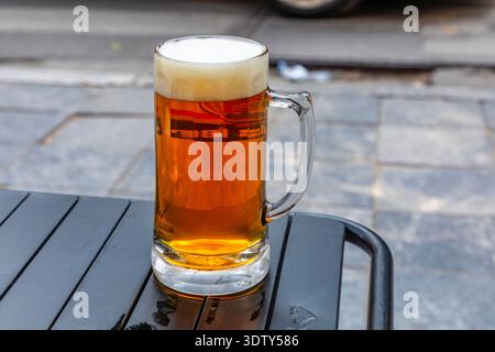 Ein Glas Bier mit einem schäumenden Kopf auf einem Tisch in Hanoi, Vietnam. Stockfoto
