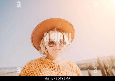 Frau in einem gelben Pullover und braunem Hut Stockfoto