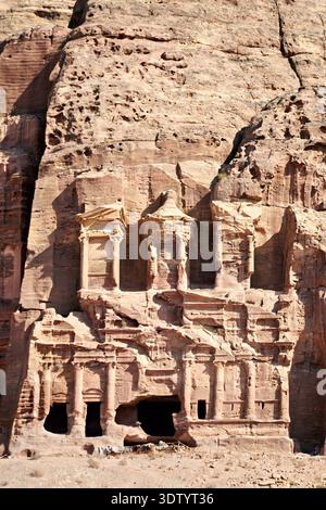 Besucher erkunden die königlichen Gräber in Petra, die zum UNESCO-Weltkulturerbe gehören. Die alten Bauten sind in den Berg gehauen. Stockfoto