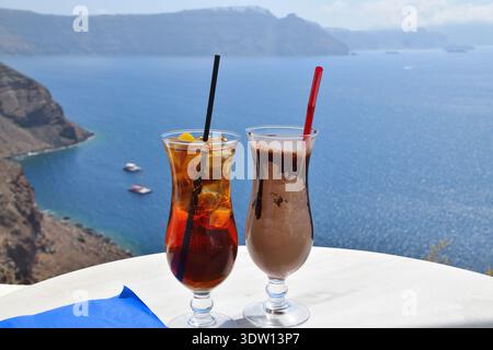 Süßer Eiskaffee und Eistee mit Meerblick vom Klippenrestaurant in Oia, Santorin Stockfoto