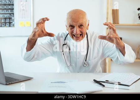 Senior männlicher Doktor wütend schreiend, aggressives Gefühl gegenüber dem Patienten, der in die Kamera blickt Stockfoto