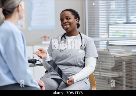 Junger Erwachsener Schwarzer weiblicher Gesundheitsexperte, der dem Patienten die Diagnose erklärt Stockfoto