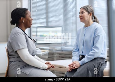 Kaukasierin mittleren Alters berät schwarze Ärztin im Klinikbüro Stockfoto