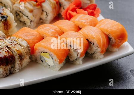 Lachs-Sushi-Brötchen mit Frischkäse auf weißem Teller, japanische Küche Stockfoto