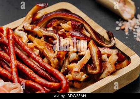 Nahaufnahme von Räucherfleisch und Räucherwürsten auf Holzbrett Gourmet-Snacksortiment Stockfoto