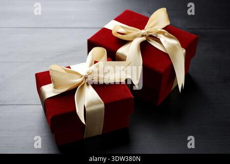 Schöne Samtgeschenkdosen auf schwarzem Holztisch Stockfoto