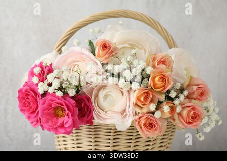 Schöne Blumen im Korb auf hellem Hintergrund, Nahaufnahme Stockfoto
