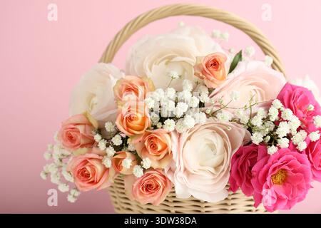 Schöne Blumen im Korb auf rosa Hintergrund, Nahaufnahme Stockfoto