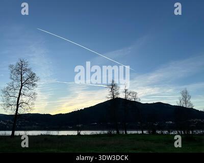 Blick auf die Berg- und Platinenkontrails am Sonnenaufgangshimmel in der Nähe von Tabagón, O Rosal, Galicien, Spanien, Dezember 2023 Stockfoto