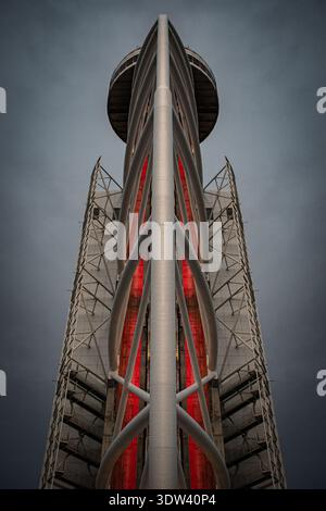 Niedrigwinkelfoto eines modernen Aussichtsturms mit symmetrischen Stahlträgern und roter Innenbeleuchtung Stockfoto