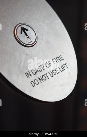 Schild mit Brandschutzvorschriften in einem Gebäudeaufzug Stockfoto