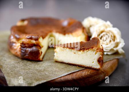 Baskischer Käsekuchen mit dunkler karamelisierter Oberseite auf Pergamentpapier Stockfoto