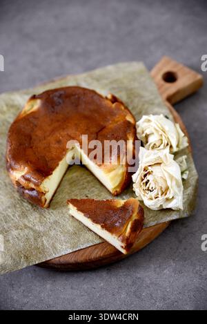 Köstlich rustikaler baskischer Käsekuchen auf einem hölzernen Servierbrett. Stockfoto