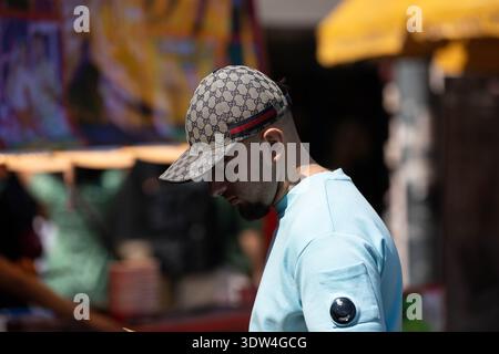 BANGKOK, THAILAND, 25. JAN 2026: Mann auf dem lokalen Markt, Person in natürlichem Sonnenlicht, männliche Hautstruktur, Seitenprofil, auf dem Chatuchak Markt Stockfoto