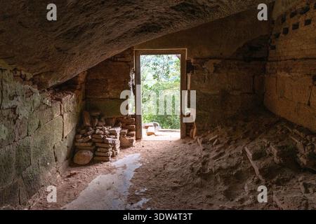 Das Innere einer historischen Felsenhöhle im alten buddhistischen Kloster in Sri Lanka, ein Ort der Meditation und spirituellen Besinnung. Stockfoto