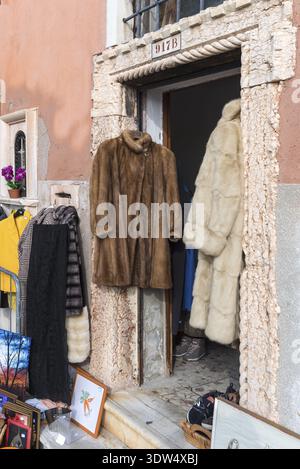 Pelzmäntel hängen in einer Tür zum Verkauf, Venedig, Venetien, Italien Stockfoto