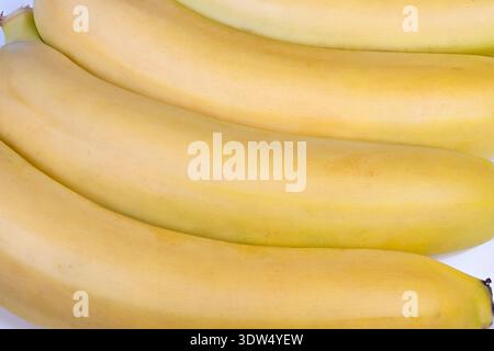 Frische Bananenanzeige. Überreife Bananen im Ladenregal mit lebhafter Beleuchtung. Gereifte Bananen, die ordentlich im Ladenregal mit lebhafter Beleuchtung platziert werden Stockfoto