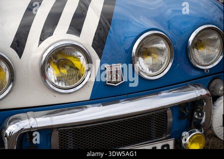 Äußerste Nahaufnahme des Renault Dauphine Gordini Emblems in Silber, das auf der blauen Vordernase eines französischen Oldtimers angebracht ist. Stockfoto