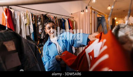 Kunde Wählt Coat. Käufer Sind In Der Lage, Verschiedene Styles Von Kleidungsstücken Zu Durchsuchen Und Zu Spüren Stockfoto