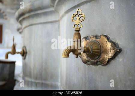 Antiker Messinghahn auf Waschbrunnen in der osmanischen Moschee, Istanbul, Türkei Stockfoto