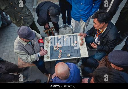 Peking, China - 3. April 2013: Chinesische Männer spielen chinesisches Schach namens Xiangqi auf der Straße in Peking Stockfoto