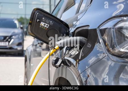 Laden eines Elektrofahrzeugs an einer öffentlichen Station Stockfoto