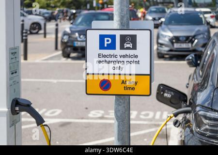 Schild für Ladestation für Elektrofahrzeuge mit eingestecktem Auto. London, UK, 28. Juli 2024 Stockfoto