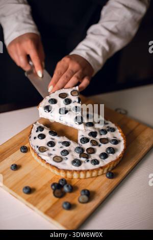 Frau, die ein Stück Heidelbeertorte hält Stockfoto