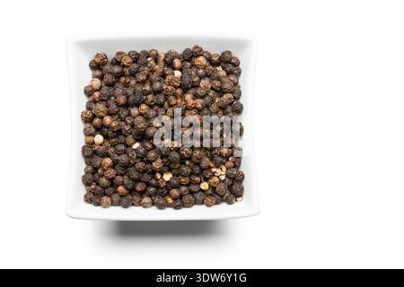 Schwarzer Pfeffermais in weiße Schüssel auf weißem Hintergrund. Stockfoto