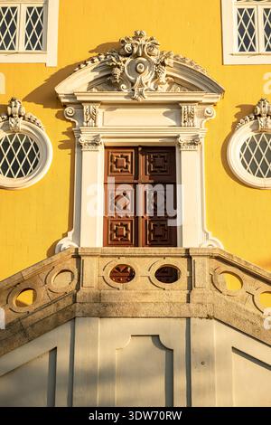 Nahaufnahme eines kunstvollen Barockeingangs in einem historischen Gebäude in Porto, Portugal, mit dekorativer Holztür und komplizierten Steinschnitzen Stockfoto