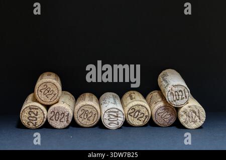 Ein Stapel Weinkorken zeigt eingeprägte Jahrgänge 20o21 vor dunklem Studiohintergrund. Athen, Griechenland - 02 16, 2026 Stockfoto