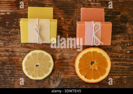 Flache Seifenriegel in Gelb und Orange, die vitaminreiche Hautpflege, nachhaltige, handgefertigte Produkte und erfrischende Wellnesskonzepte hervorheben. Stockfoto