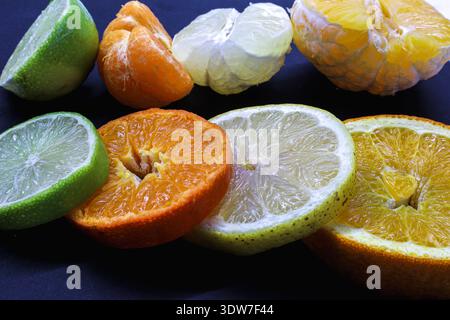 Nahaufnahme-Sortiment aus geschnittenen Zitronen, Orangen, Limetten und Mandarinen, ideal für Wellness-, Detox- und Bio-Beauty-Konzepte. Stockfoto