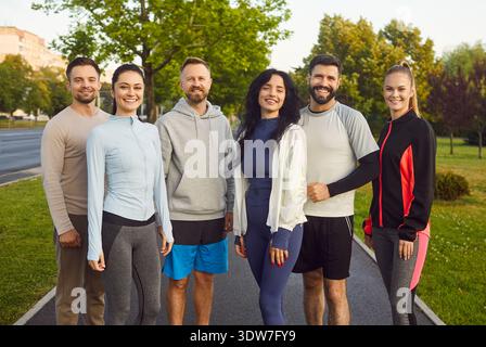 Gruppe glücklicher Läufer, die nach dem Joggen im Sommer-Stadtpark zusammen stehen Stockfoto
