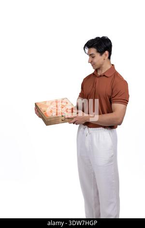 Liefermann in kastanienbraunem Hemd, der dem Kunden eine Pizzaschachtel gibt Stockfoto