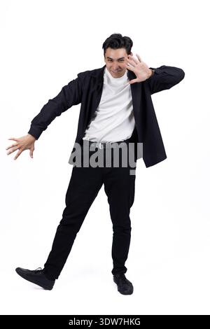Glücklicher Geschäftsmann in schwarzem Anzug, der im Studio Erfolg feiert Stockfoto
