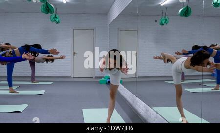 Gruppen-Yoga-Session mit Menschen, die im Fitnessstudio Balance üben Stockfoto