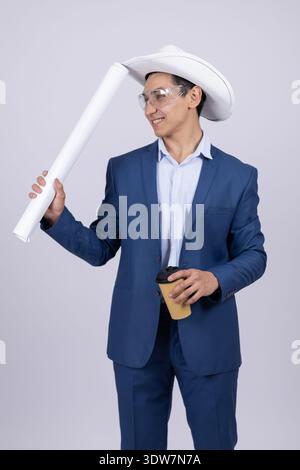 Geschäftsmann im blauen Anzug, der Papierrollen im Studio hält Stockfoto