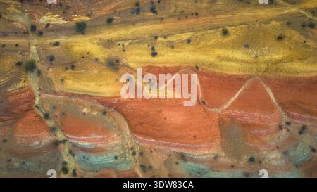 Mehrfarbige Wüstenlandschaft mit gewundenen Trail und Lava Butte Top Down Stockfoto