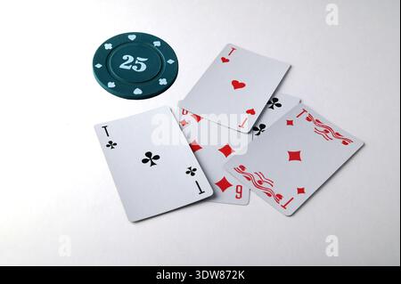 Aces spielen Karten mit einem 25 usd Casino Chip auf weißem Hintergrund. Stockfoto