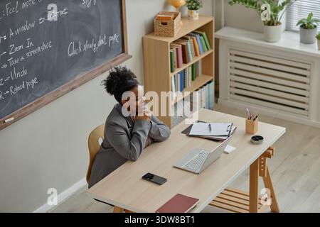 Junge Schwarze Frau unterrichtet Computerkompetenz mit Laptop im Klassenzimmer Stockfoto