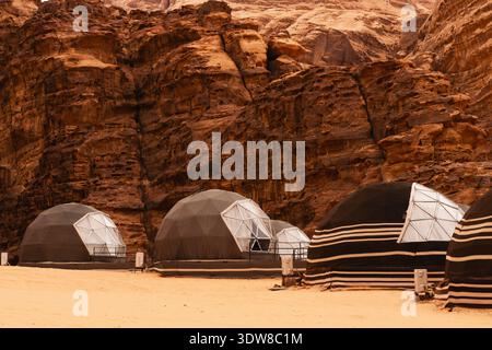Die Zelte sind auf sandigem Boden im felsigen Gebiet des Jordantals angeordnet. Wadi Rum Wüste, Jordanien, das Tal des Mondes. Stockfoto