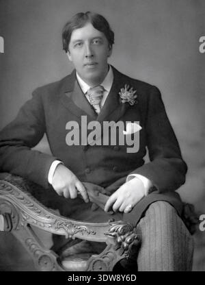 Dieses auffällige Schwarz-weiß-Porträt aus dem Jahr 1889 zeigt den irischen Dichter und Dramatiker Oscar Wilde, fotografiert von W. und D. Downey. Wilde sitzt elegant und trägt einen Anzug mit einer Boutonnière, der seine unverwechselbare ästhetische und intellektuelle Präsenz zum Ausdruck bringt. Stockfoto