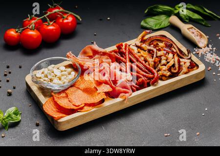 Verschiedene Wurstwaren und Snacks serviert auf Holzbrett Gourmet-Vorspeiseteller Stockfoto