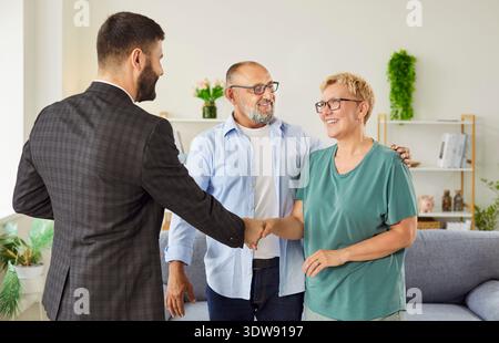 Immobilienmakler schüttelt nach Vereinbarung zu Hause die Hand mit einem reiferen Paar Stockfoto